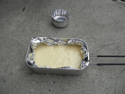 メスティンに焦げ付き防止のためにアルミホイルを引いて、ホットケーキの素を入れます。
ストーブは高さ30mmに修正したものです。
五徳は必要ないのですが、炎を広げたいのでいつもの五徳を使用しました。
アルコールは30cc入れて焼き始めましたが、継ぎ足して焼き終わるまでに計100ccほど使いました。継ぎ足しは燃焼が終わってから行っているので、連続したらたぶん、80ccで足りると思います。